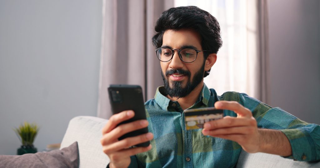 indian man with credit card and phone scaled